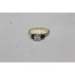 AN 18CT GOLD THREE STONE LADIES RING, a diamond flanked by two sapphires