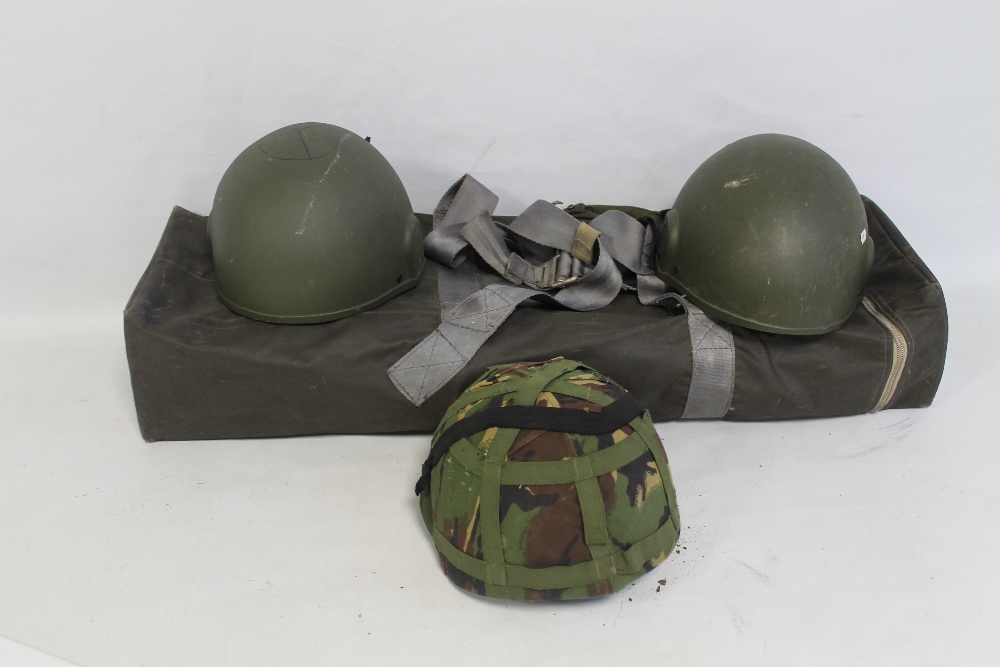 THREE BRITISH ARMY KEVLAR COMBAT HELMETS, two with fabric camouflage covers, together with a G-Q Pa