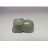 A DARKER GREEN CHINESE CELADON PENDANT OF A RECUMBENT CAT AND KITTEN, finely carved detail, L 4.4