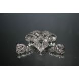 A DIAMOND SET BROOCH AND EARRINGS SET, the brooch set in white metal and measuring 4.5 cm in width