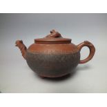 AN ORIENTAL TERRACOTTA SQUAT BALUSTER TEAPOT, with incised decoration to the body, character mark to