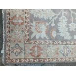 AN EASTERN WOOLLEN 20TH CENTURY RUG / CARPET, the floral central pattern on a mainly green ground