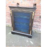 A LATE VICTORIAN EBONISED SINGLE DOOR GLAZED DISPLAY CABINET, having gilt metal mounts, raised on