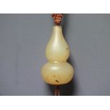 A CHINESE YELLOW JADE GOURD PENDANT, finely carved in simple form, H 5 cm, suspended form a silk