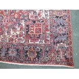 A LARGE EASTERN 20TH CENTURY WOOLLEN RUG, with an all over floral spreading pattern, mainly dark