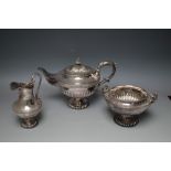 AN ORNATE SILVER PLATED THREE PIECE TEA SERVICE, teapot W 30 cm