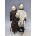 TWO ANTIQUE FOLK ART WOODEN PEG DOLLS, dressed in period costume, having wooden carved 'peg' limbs