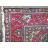 A LARGE EARLY 20TH CENTURY WOOLLEN RUG / CARPET, a central shaped diamond cartouche, with floral