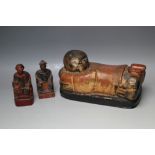 AN ORIENTAL HEAD REST IN THE FORM OF A LYING FIGURE, W 29.5 cm together with two smaller junk gods