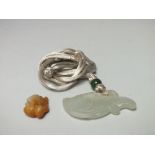 A CARVED CELADON AND BROWN JADE MINIATURE PENDANT, finely carved in the form of a toad seated upon a