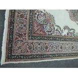 A 20TH CENTURY EASTERN WOOLLEN RUG, mainly cream ground with contrasting border in pinks and