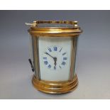 AN 8 DAY STRIKING OVAL CASED CARRIAGE CLOCK, the white enamel face with blue Roman numerals and