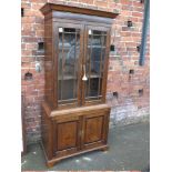 A REPRODUCTION GLAZED OAK DISPLAY CABINET, the upper section with two glazed doors,the cupboard