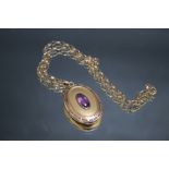 AN AMETHYST SET OVAL YELLOW METAL PENDANT ON CHAIN, the pendant measures approx 4 cm x 3 cm