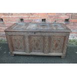 A LATE 18TH CENTURY OAK CARVED COFFER, with triple panel front and lid, H 65 cm, W 123 cm, D 57 cm