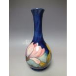 A MOORCROFT 'MAGNOLIA' PATTERN SMALL BOTTLE SHAPED VASE, blue ground with typical tubelined