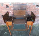 AN OAK EARLY 20TH CENTURY ARTS AND CRAFTS STYLE DESK, the hinged lid opening to reveal a fitted