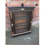 A LATE VICTORIAN EBONISED SINGLE DOOR GLAZED CABINET, having gilt metal mounts, raised on bun