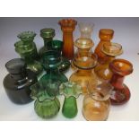 A COLLECTION OF VICTORIAN GLASS HYACINTH VASES, in shades of green and amber, various styles,