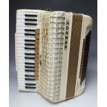 A CASED HOHNER ATLANTIC IV DELUXE ACCORDION, 120 bass keys, finished in cream with gilt fittings and