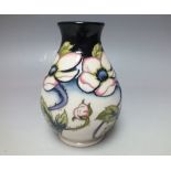 A MOORCROFT FLORAL PATTERN SMALL VASE, white graduating upwards to dark blue ground with floral