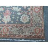 AN EASTERN 20TH CENTURY WOOLLEN RUG / CARPET, the central floral pattern with similar banding to the