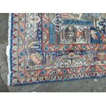 A LARGE EASTERN WOOLLEN EARLY 20TH CENTURY RUG / CARPET, the central cartouche with figurative