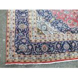 A LARGE EASTERN 20TH CENTURY WOOLLEN RUG, with an all over floral cartouche on a mainly blue and red