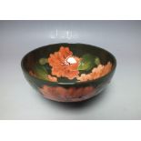 A MOORCROFT 'HIBISCUS' PATTERN SMALL FOOTED BOWL, green ground with typical tubelined decoration,