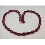 A SINGLE STRAND OF VINTAGE CHERRY AMBER BEADS, beads are slightly graduated in size, screw barrel