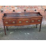 A GEORGIAN OAK THREE DRAWER DRESSER, with later rail, raised on squared supports, H 99 cm, W 185 cm,