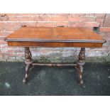 A VICTORIAN WALNUT SHAPED RECTANGULAR TABLE, raised on turned carved supports united by a turned