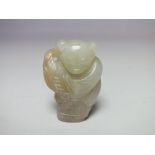 A CHINESE CELADON JADE FIGURE OF A STANDING BOY, finely carved detail, the boy bearing a vase of