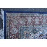 A SMALL EASTERN WOOLLEN RUG, floral decoration throughout, mainly blue ground, 180 x 121 cm