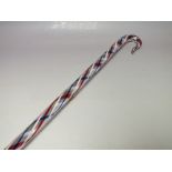 A VINTAGE NAILSEA GLASS WALKING CANE, having a spiral twist design core in blue, red and white,