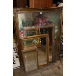 A LARGE GILT FRAMED FLORAL PRINT TOGETHER WITH THREE BEVEL EDGED MIRRORS