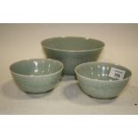THREE CHINESE TYPE CELADON BOWLS, featuring Koi carp amongst the water lilies, largest Dia 16.25 cm