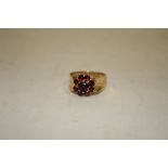 A LADIES 9CT GOLD FLORAL SET GARNET DRESS RING