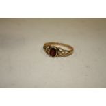 A LADIES 9CT GOLD GARNET DRESS RING IN A CELTIC STYLE SETTING