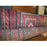 AN ANTIQUE RED/BLACK WOOLLEN RUG