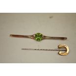 A LONG YELLOW METAL BAR BROOCH SET WITH A PERIDOT TYPE STONE TOGETHER WITH A HORSE SHOE SHAPED HAT