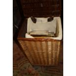 A WICKER BASKET CONTAINING PICTURE FRAMES