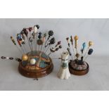 A COLLECTION OF HAT PINS on two cushion type bases, to include glass and ceramic topped examples and