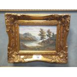 A SMALL GILT FRAMED OIL ON BOARD OF A MOUNTAINOUS LAKE SCENE, INDISTINCTLY SIGNED LOWER RIGHT