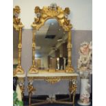 A HUGE GILT MARBLE TOPPED CONSOLE TABLE WITH MIRROR, DECORATED WITH FIGURATIVE CHERUBIC DETAIL - H