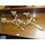 A PAIR OF ROCOCO STYLE GILT METAL TWO BRANCH WALL LIGHTS, staggered foliate cast sconces on