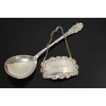 AN ART NOUVEAU CONTINENTAL SILVER SPOON TOGETHER WITH A HALLMARKED SILVER DECANTER LABEL