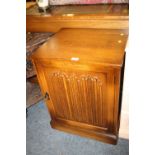 AN OAK LINENFOLD CUPBOARD