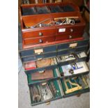 A WATCHMAKERS TEN DRAWER DESKTOP CHEST OF DRAWERS CONTAINING WATCHMAKERS TOOLS, CLOCK PARTS ETC.