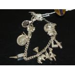 A SILVER CHARM BRACELET AND CHARMS TOGETHER WITH A GWR RAILWAY SERVICE ENAMELLED BADGE